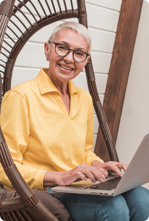 Woman in yellow shirt working on laptop